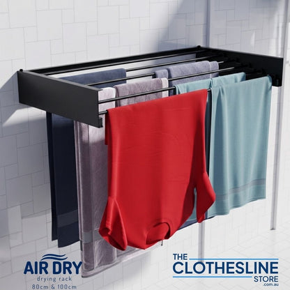 Wall-mounted Air Dry 100 clothes airer with laundry hanging on a tiled wall - colour black.
