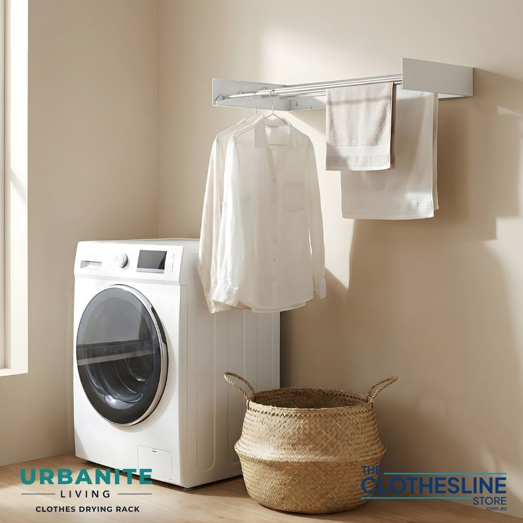 Urbanite Living Drying Rack installed on the wall in a laundry with towels hung over the lines and shirts hanging from clothes hangers.